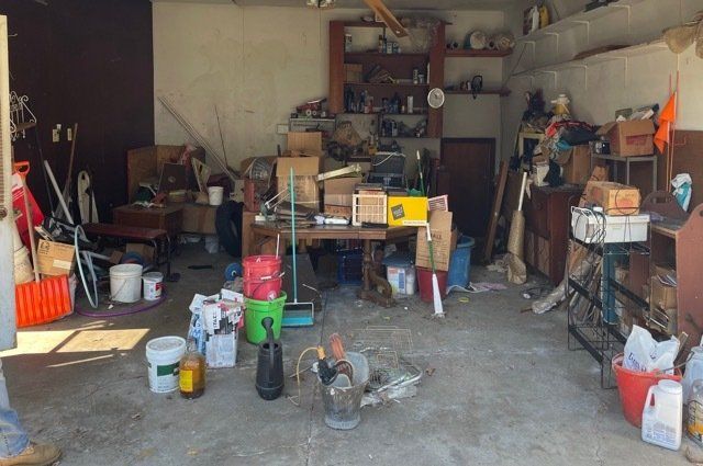 Junk Pickup Before Picture.  Piles of miscellaneous junk inside of garage