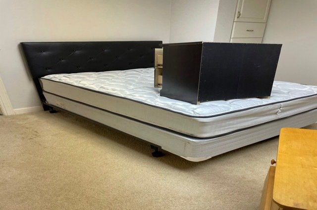 a bed  and a mattress with a black dresser on top of it