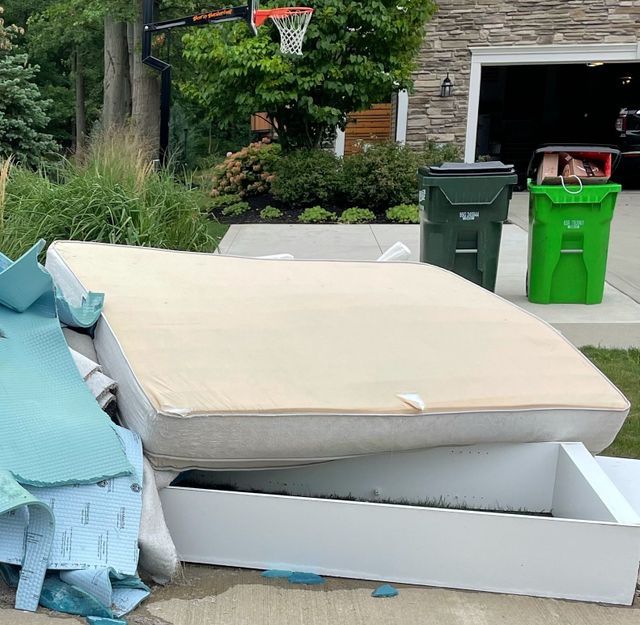 mattress , bed frame, and carpet on the curb for pickup