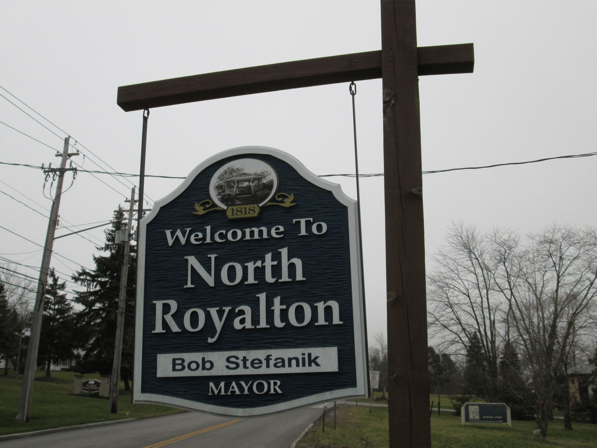 a blue and white sign hanging that says welcome to north royalton