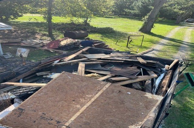 a truck bed full of a torn down shed and construction debris