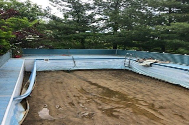 empty above ground pool with sand underneath