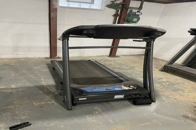 treadmill in white basement with clean concrete floor
