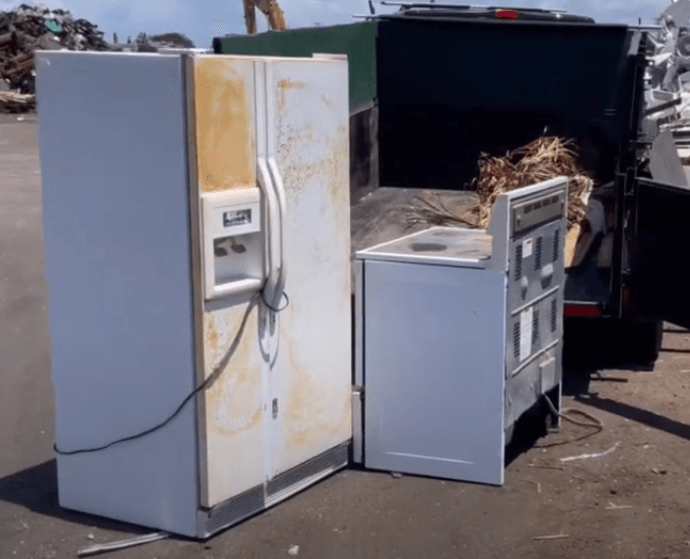 white refrigerator and white oven that have both been hauled out of a home