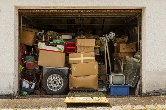 Opened garage that is filled from floor to ceiling with junk