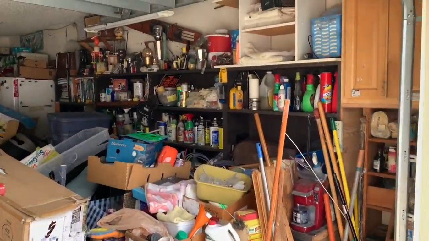 overfilled garage full of boxes, tools, cleaners, and other miscellaneous items