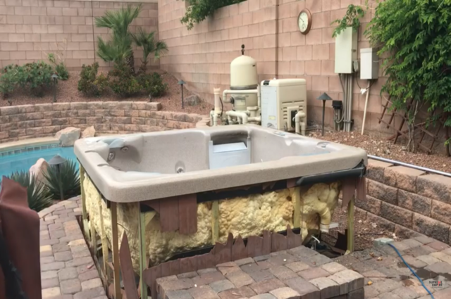 hot tub in a backyard that is missing its front panel