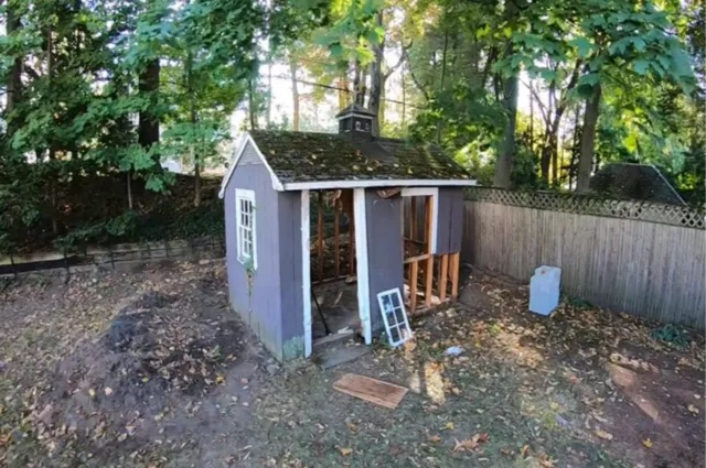 a shed that is missing a door and a window that is partially disassembled