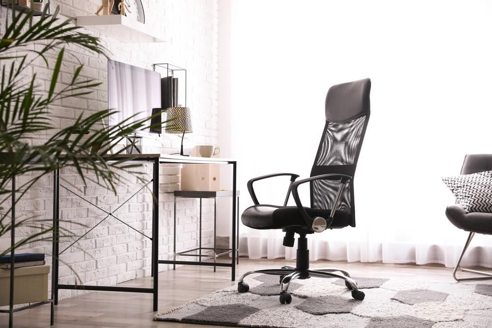 A Black Office Chair Is Sitting In A Living Room Next To A Desk — Viison Kitchens & Joinery Forster In Forster, NSW
