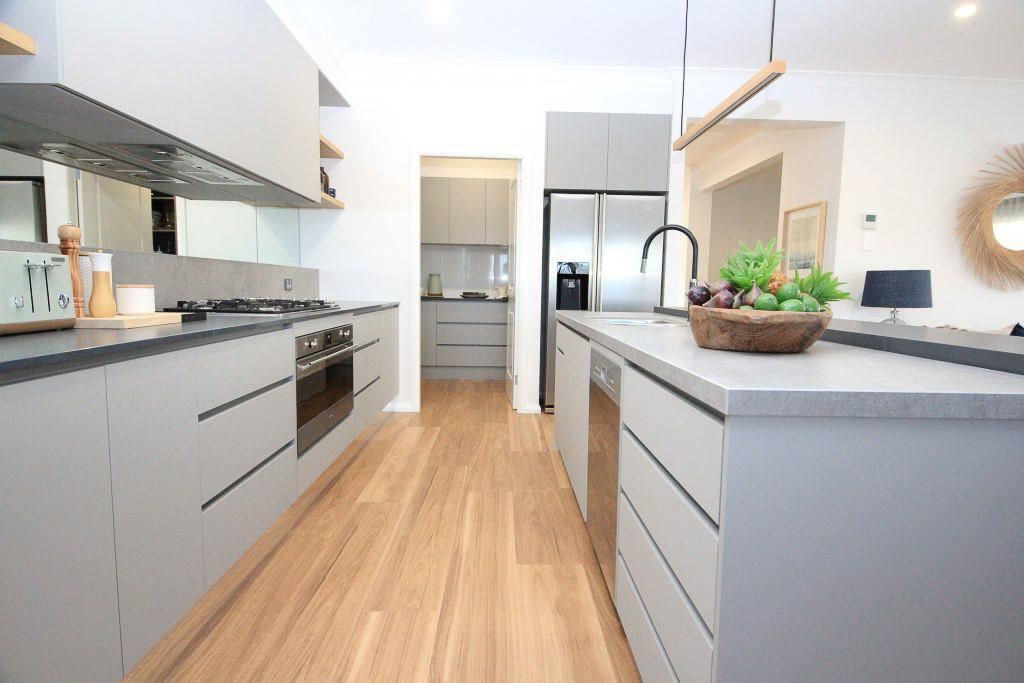 A Kitchen With White Cabinets And A Wooden Floor — Viison Kitchens & Joinery Forster In Forster, NSW