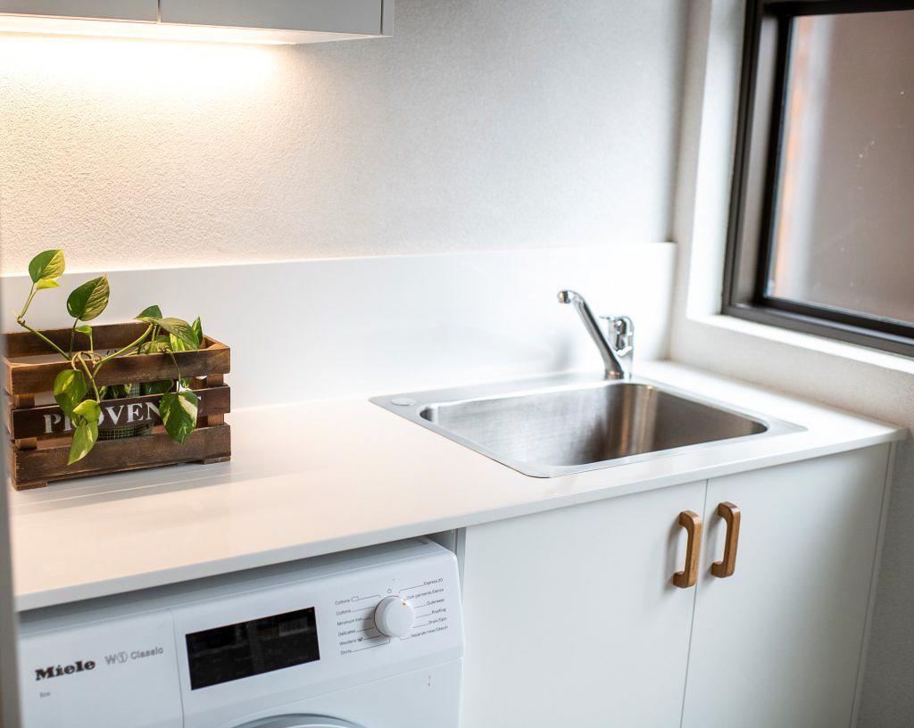 A Laundry Room With A Sink , Washer And Dryer — Viison Kitchens & Joinery Forster In Forster, NSW