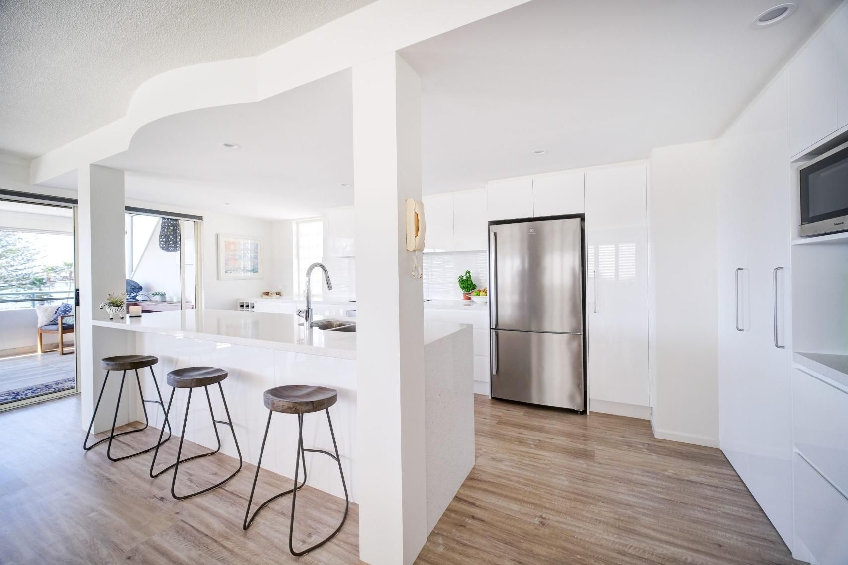 A Kitchen With White Cabinets And Stools — Viison Kitchens & Joinery Forster In Forster, NSW