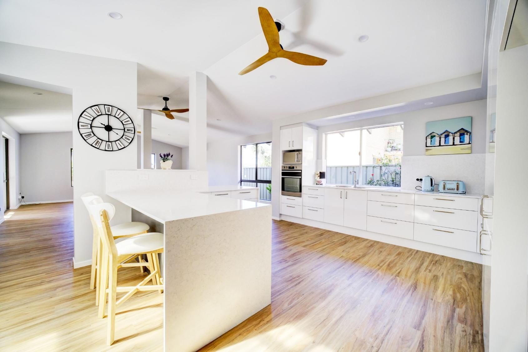 A Kitchen With A Clock On The Wall And A Ceiling Fan — Viison Kitchens & Joinery Forster In Port Macquarie, NSW