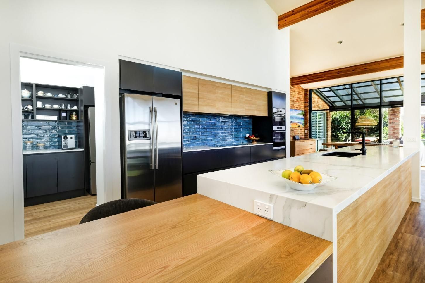 A Kitchen With A Large Island And A Bowl Of Fruit On The Counter — Viison Kitchens & Joinery Forster In Taree, NSW