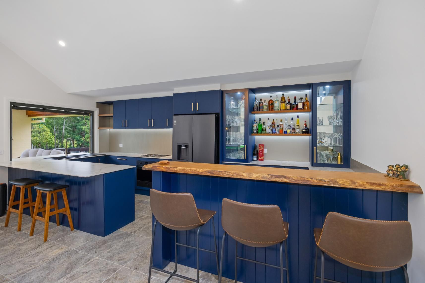 A Kitchen With A Bar And Stools And A Refrigerator — Viison Kitchens & Joinery Forster In Forster, NSW