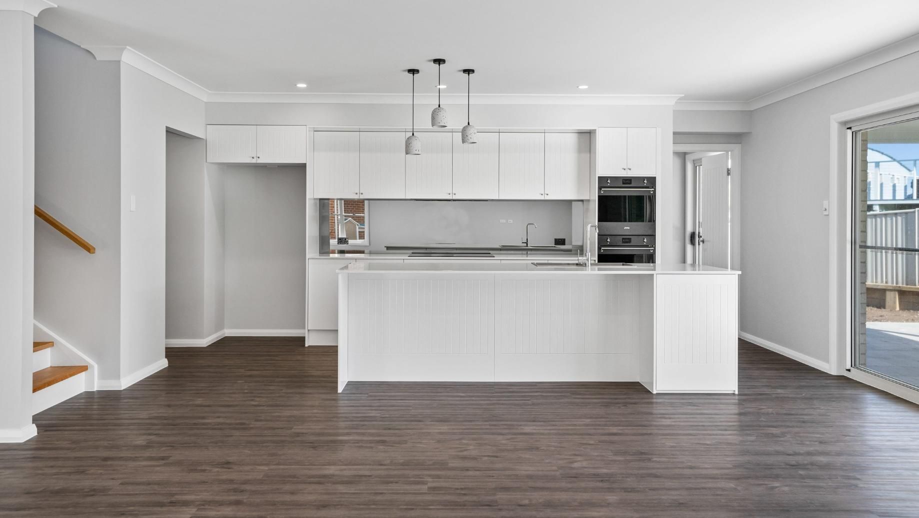An Empty Kitchen With White Cabinets And A Wooden Floor — Viison Kitchens & Joinery Forster In Port Macquarie, NSW