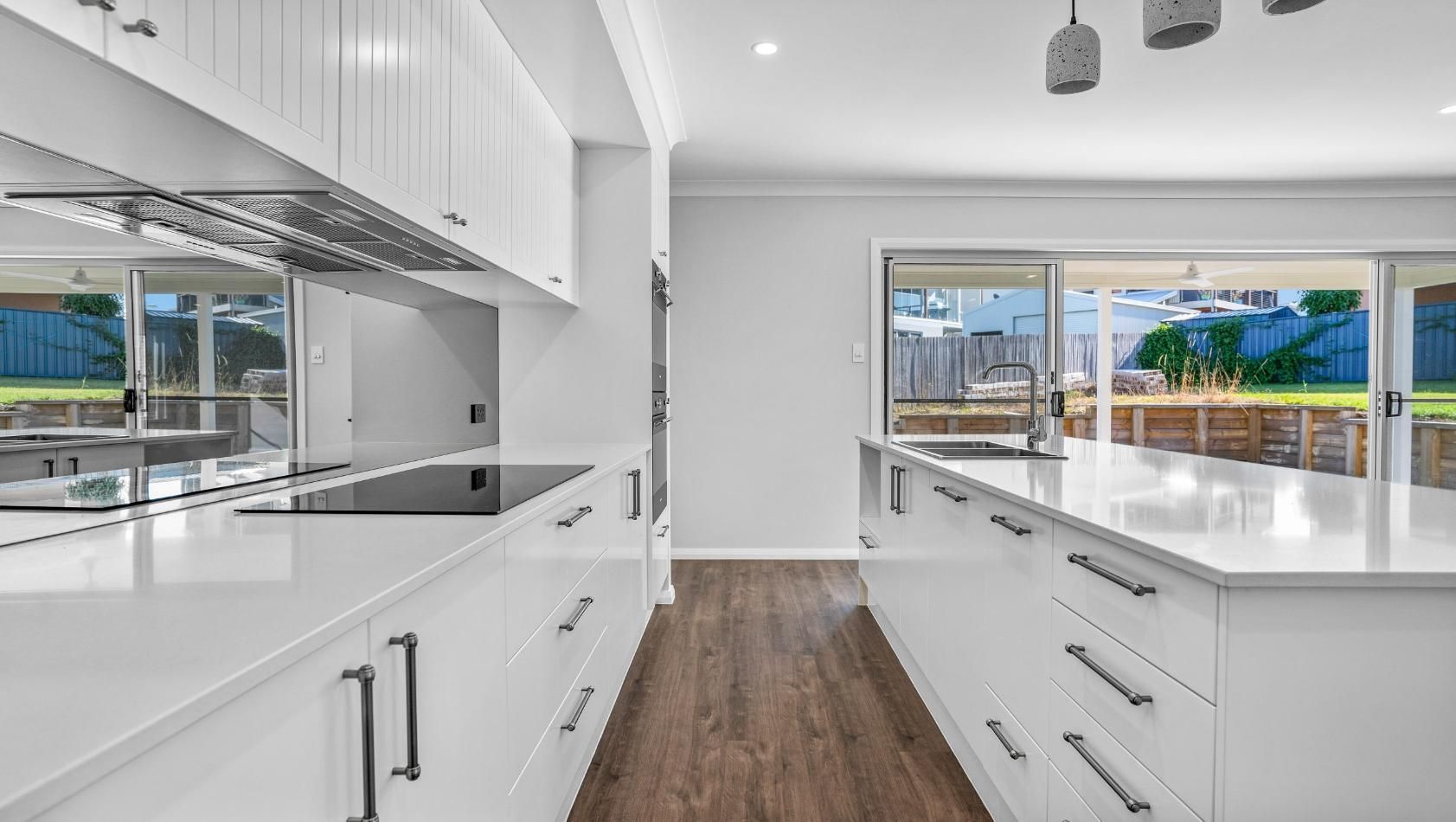 A Kitchen With White Cabinets , A Stove Top Oven , And A Large Island — Viison Kitchens & Joinery Forster In Forster, NSW
