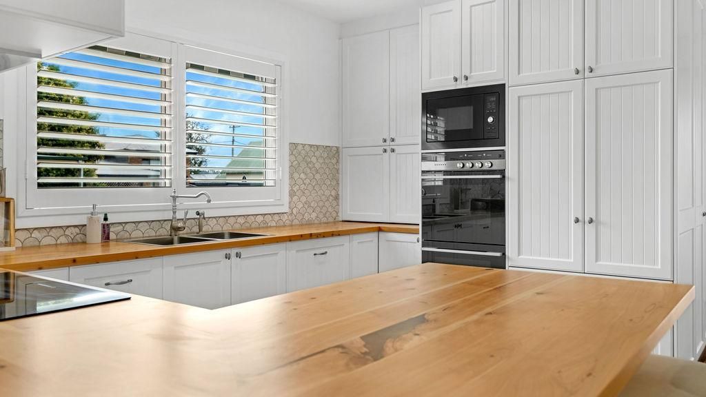 A Kitchen With White Cabinets And A Wooden Counter Top — Viison Kitchens & Joinery Forster In Forster, NSW