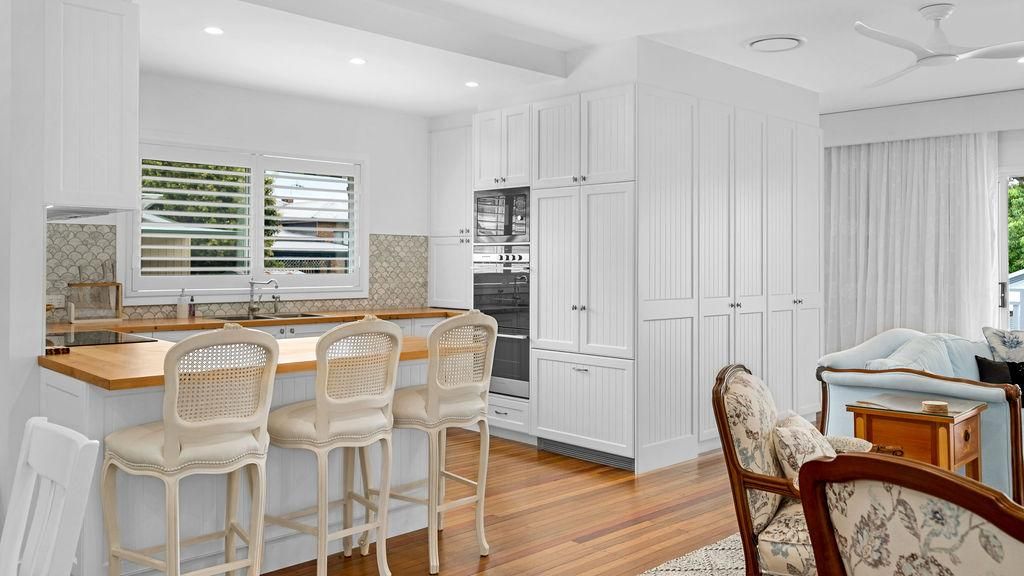A Kitchen With Cabinets , Stools And A Ceiling Fan — Viison Kitchens & Joinery Forster In Gloucester, NSW