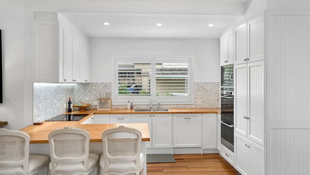 A Kitchen With White Cabinets And A Wooden Counter Top — Viison Kitchens & Joinery Forster In Gloucester, NSW