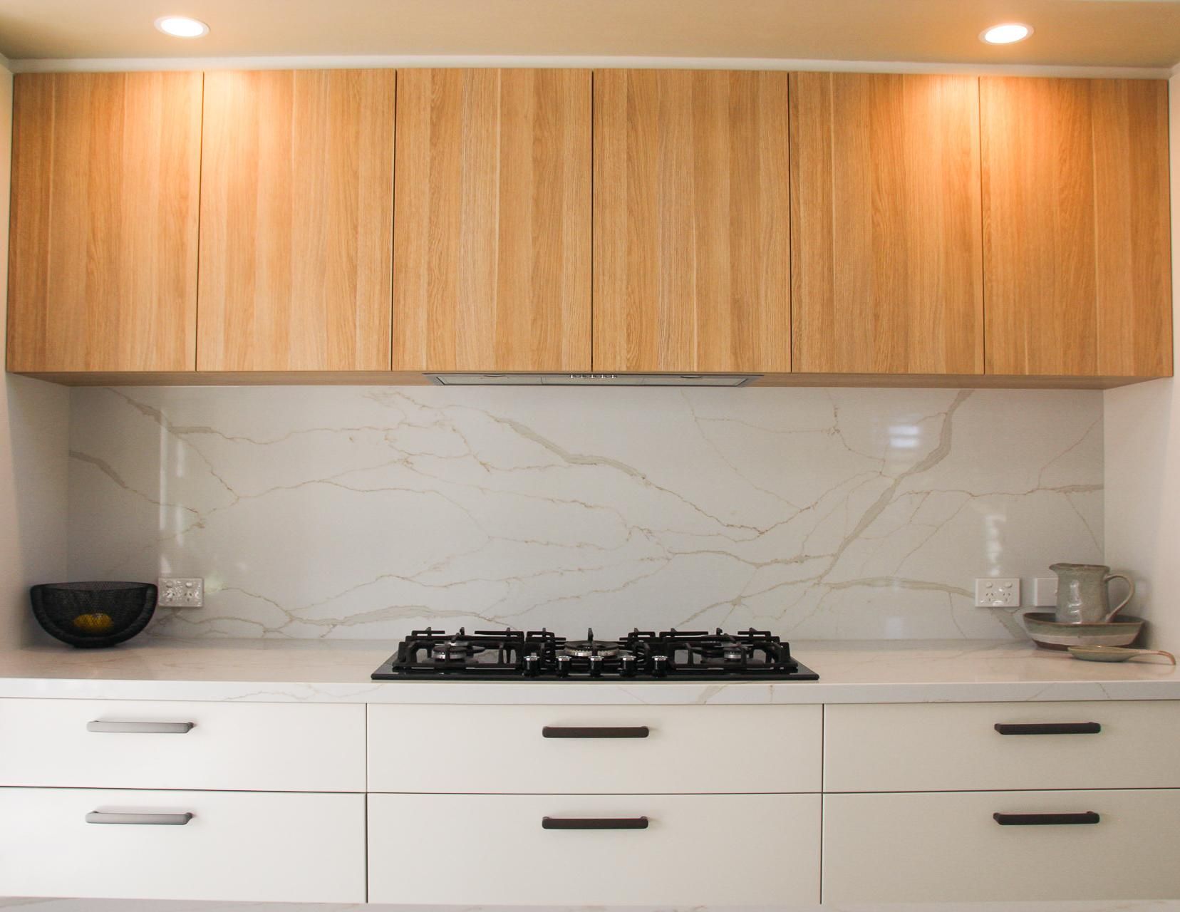 A Kitchen With White Cabinets And A Stove Top Oven — Viison Kitchens & Joinery Forster In Forster, NSW