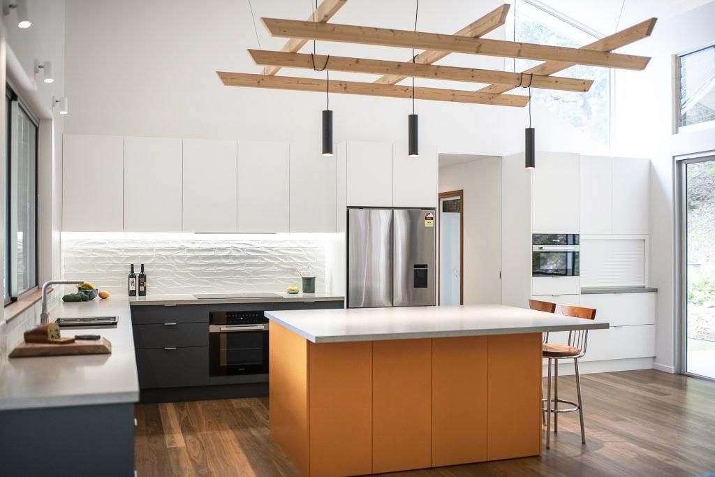 A Kitchen With Orange Cabinets , White Cabinets And A Large Island — Viison Kitchens & Joinery Forster In Forster, NSW
