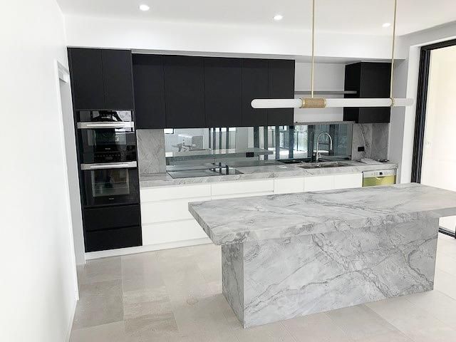 A Kitchen With A Marble Counter Top And Black Cabinets — Viison Kitchens & Joinery Forster In Old Bar, NSW