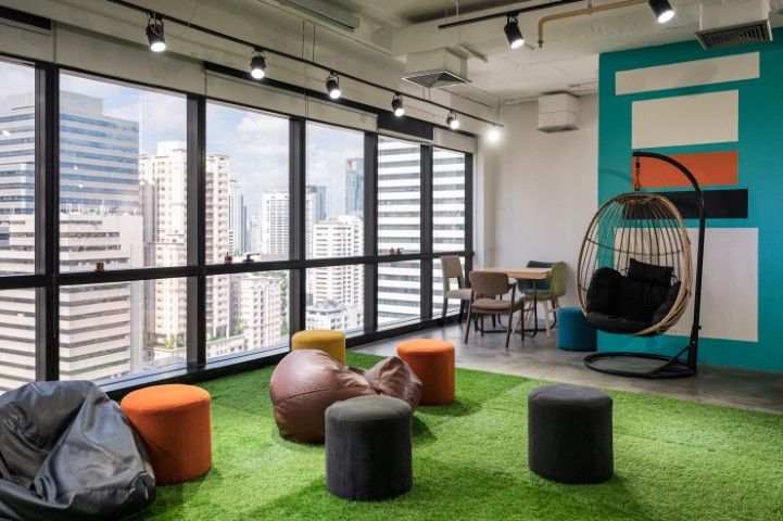 Modern office with cityscape view; features green