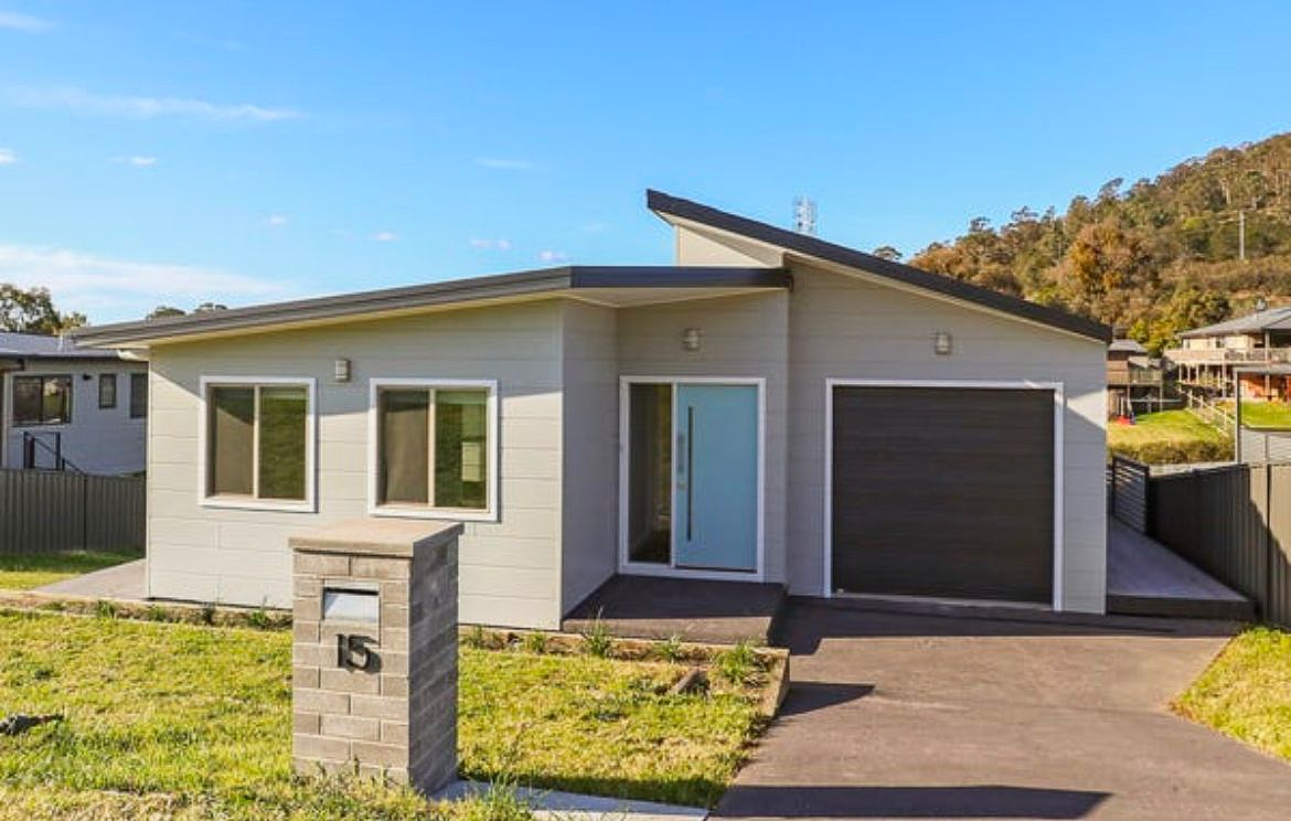 Gray house with blue door and dark garage door, stone mailbox, sunny day. — Hallam & Sons in Beard, ACT
