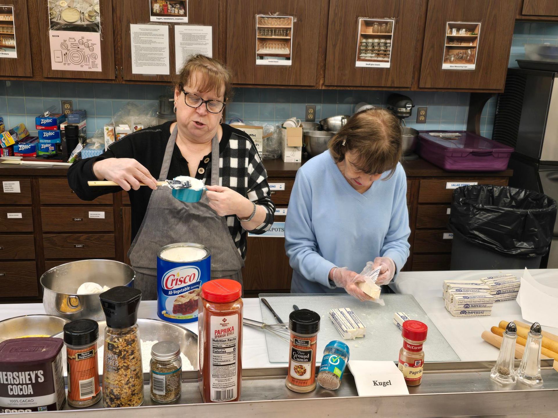 Two women are preparing food in a kitchen.