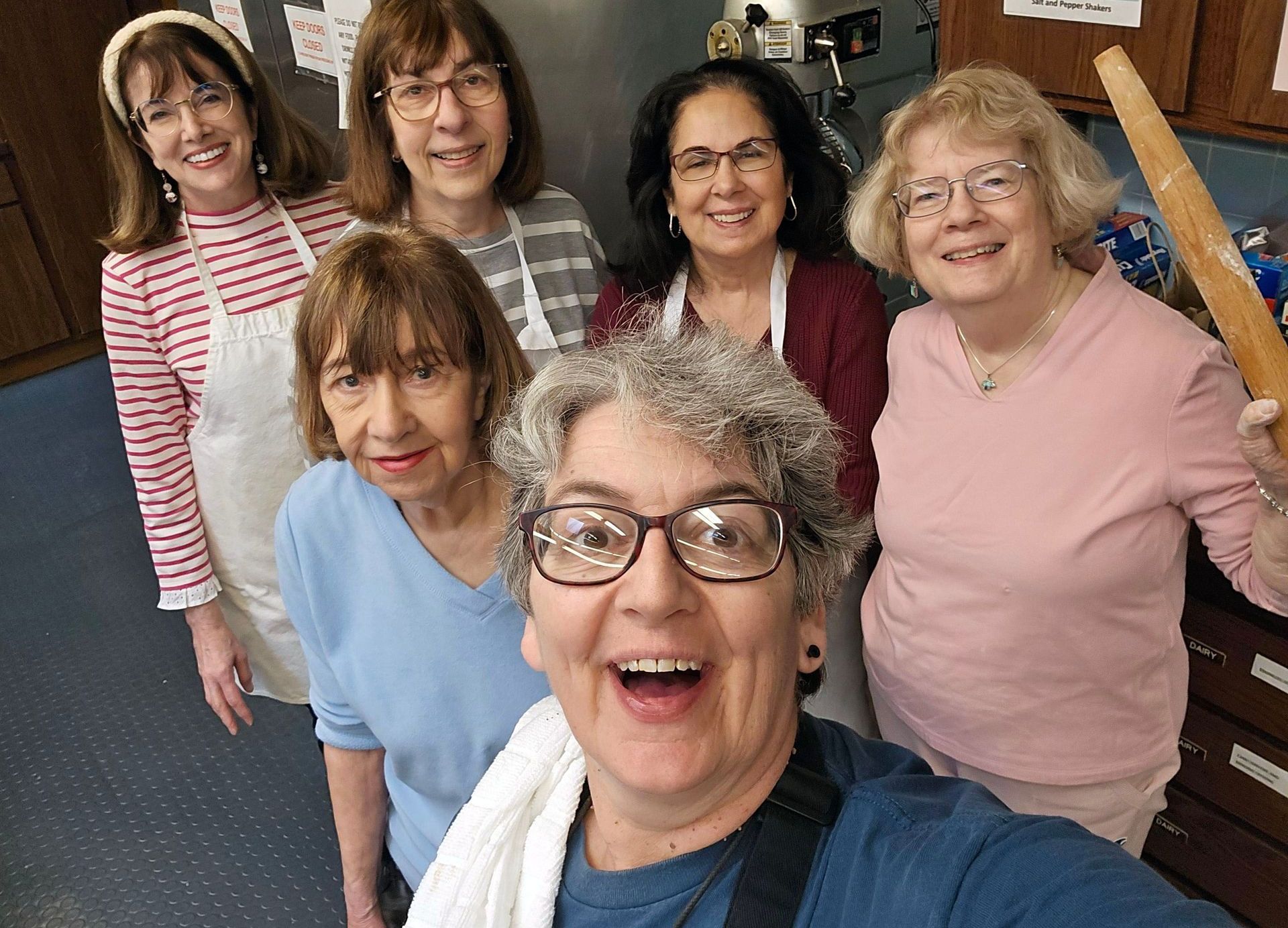 A group of women are posing for a selfie in a kitchen.