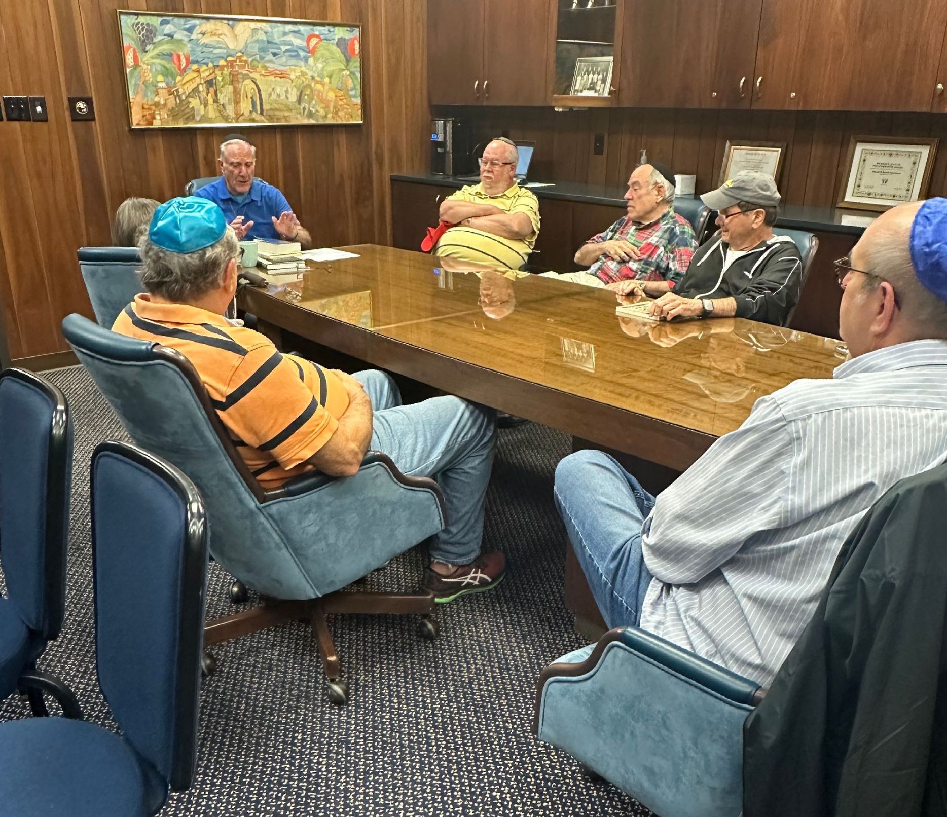 Three men are posing for a picture in front of a wooden wall.