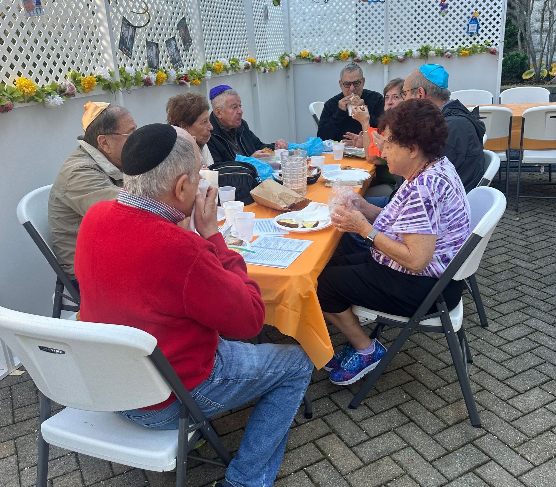 A group of people are sitting around a table eating food.