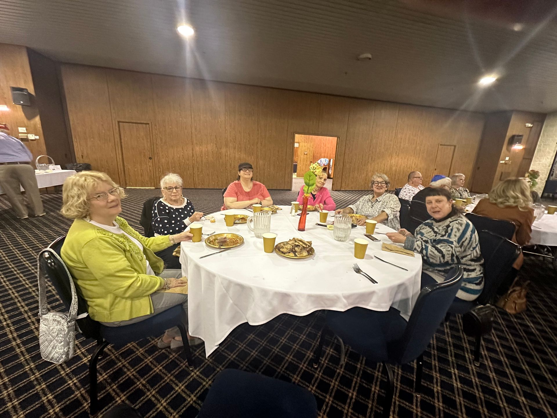A group of people are sitting around a table eating food.