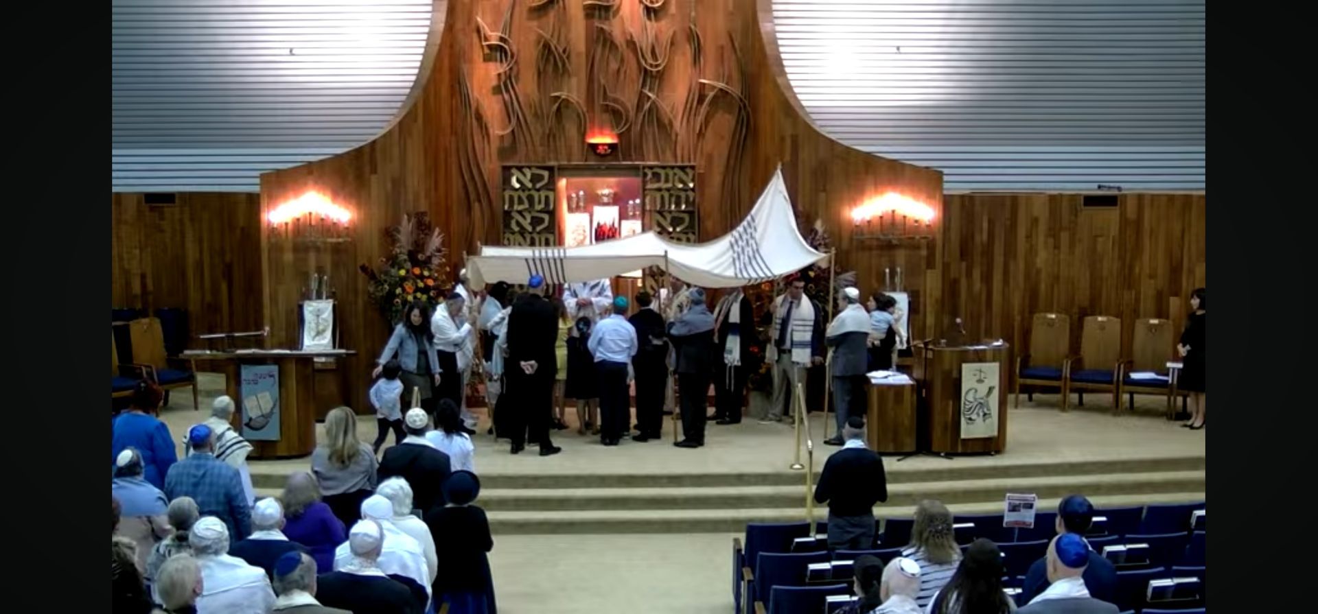 A group of people are standing in front of a wooden altar in a church.