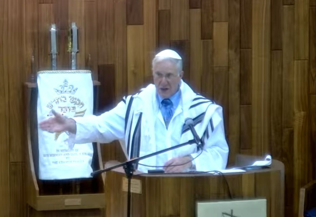 Two men are standing on a stage with their arms in the air.