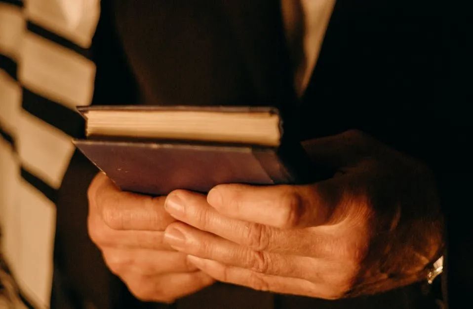 A man in a suit is holding a book in his hands.