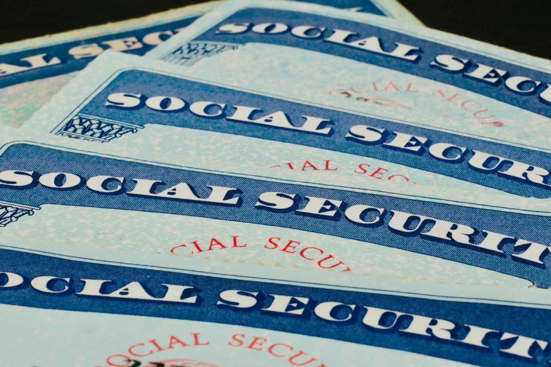 Stack of overlapping U.S. Social Security cards with blue text.