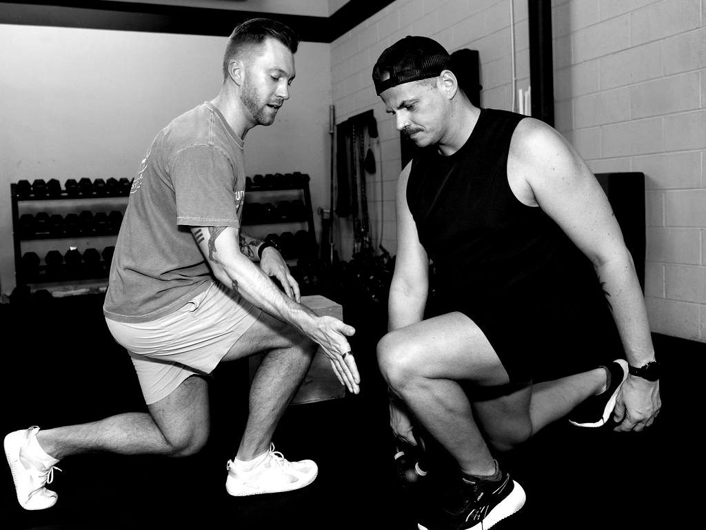 A black and white photo of a woman holding a kettlebell