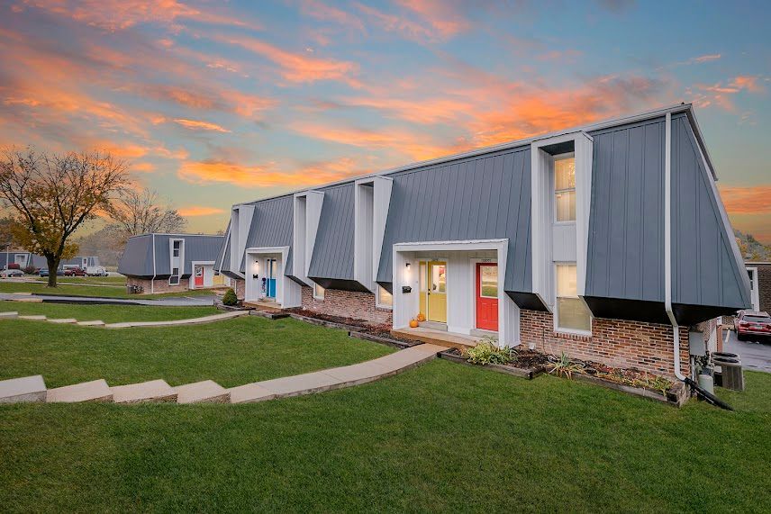 A row of apartment buildings with a sunset in the background.