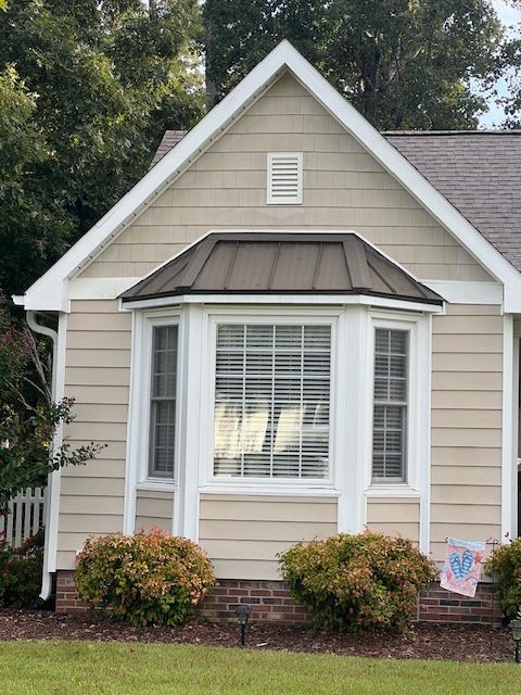 A small house with a bay window and a roof — Jacksonville, NC — JW Roofing & Exteriors
