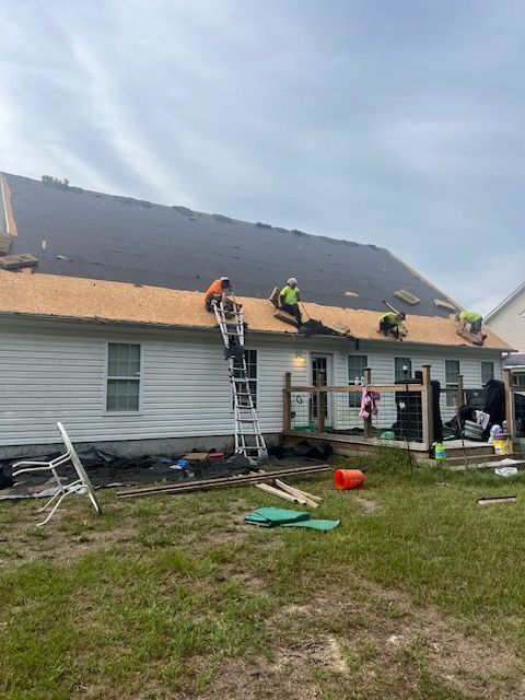A group of people are working on the roof of a house — Jacksonville, NC — JW Roofing & Exteriors
