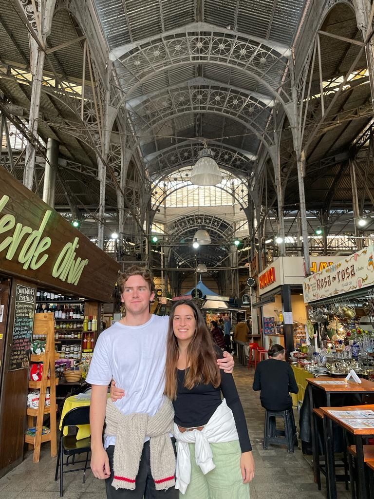 a man and a woman are posing for a picture in a market . Gap year Argentina