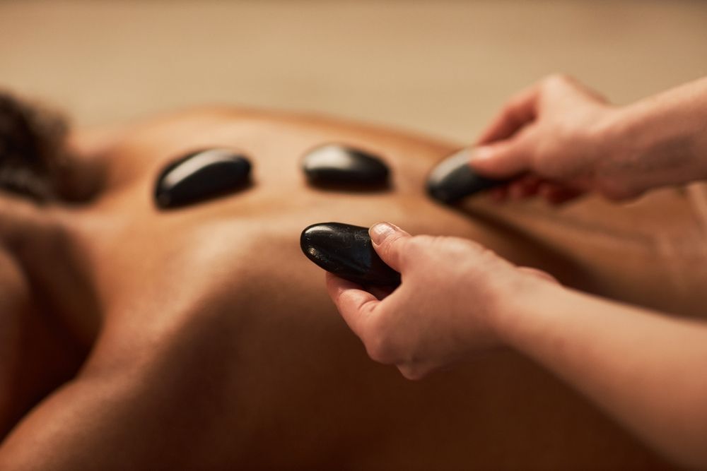 Woman receiving hot stones massage.