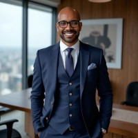 A man in a suit and tie is standing in an office with his hands in his pockets.