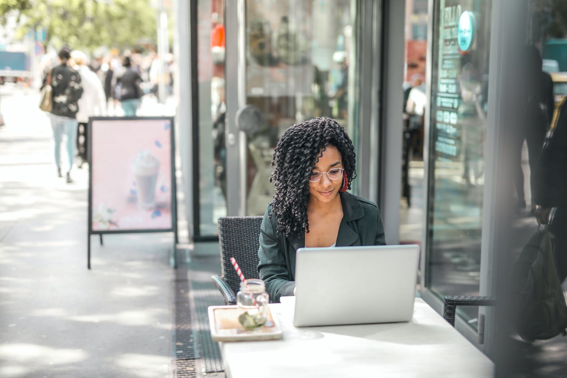 A woman is sitting at a table using a laptop computer.