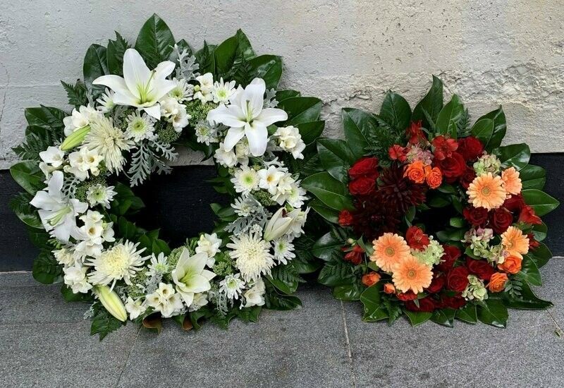 two wreaths of flowers are sitting next to each other