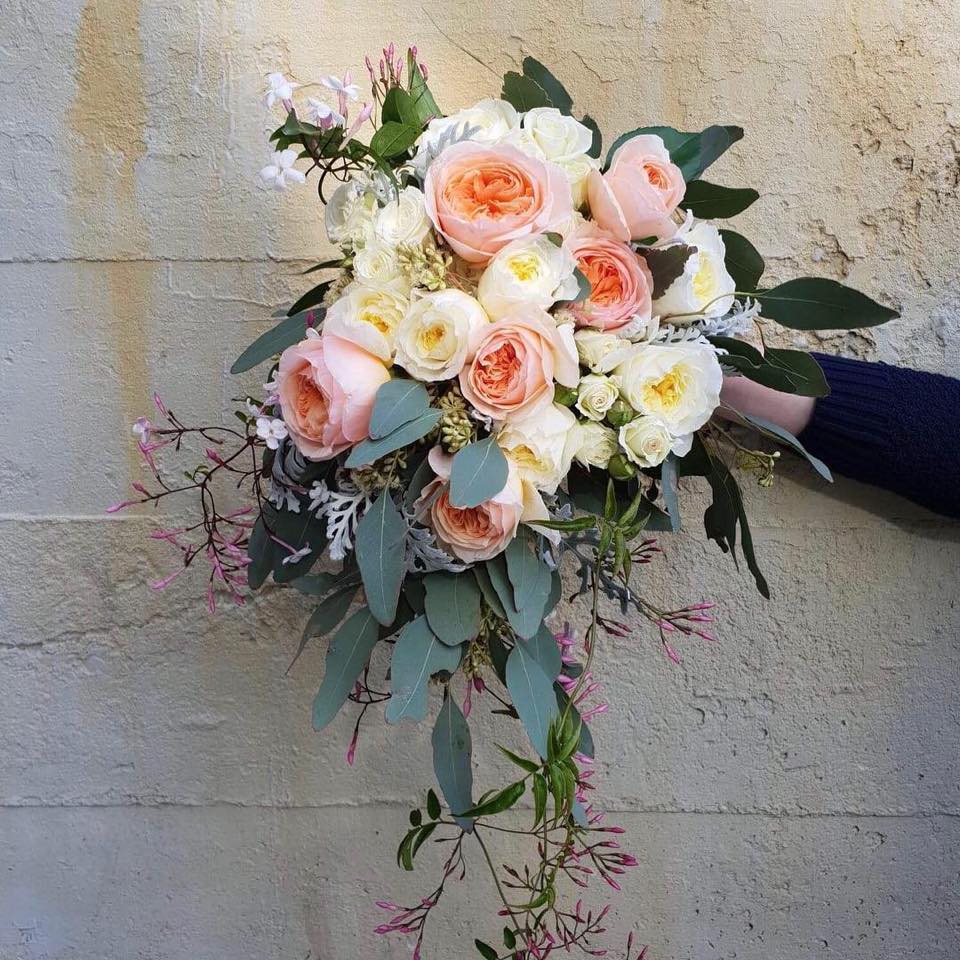 a person is holding a bouquet of pink and white flowers