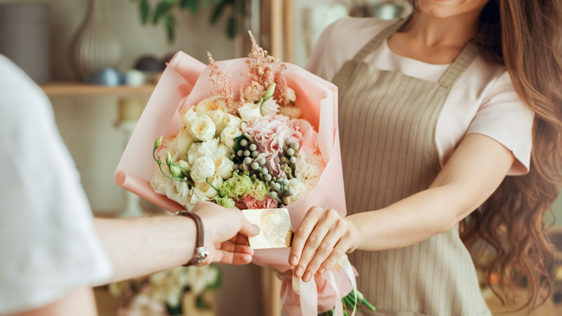 a woman is giving a bouquet of flowers to a man .