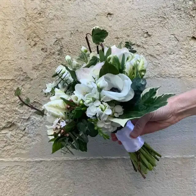 a person is holding a bouquet of white flowers